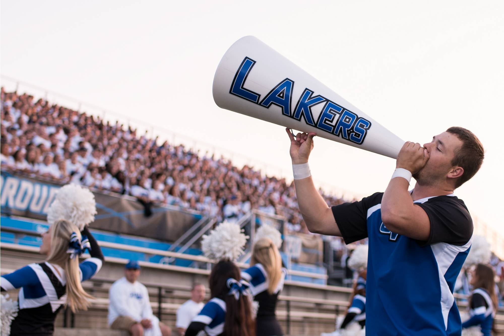 Male cheerleader with megaphone labeled "Lakers"
